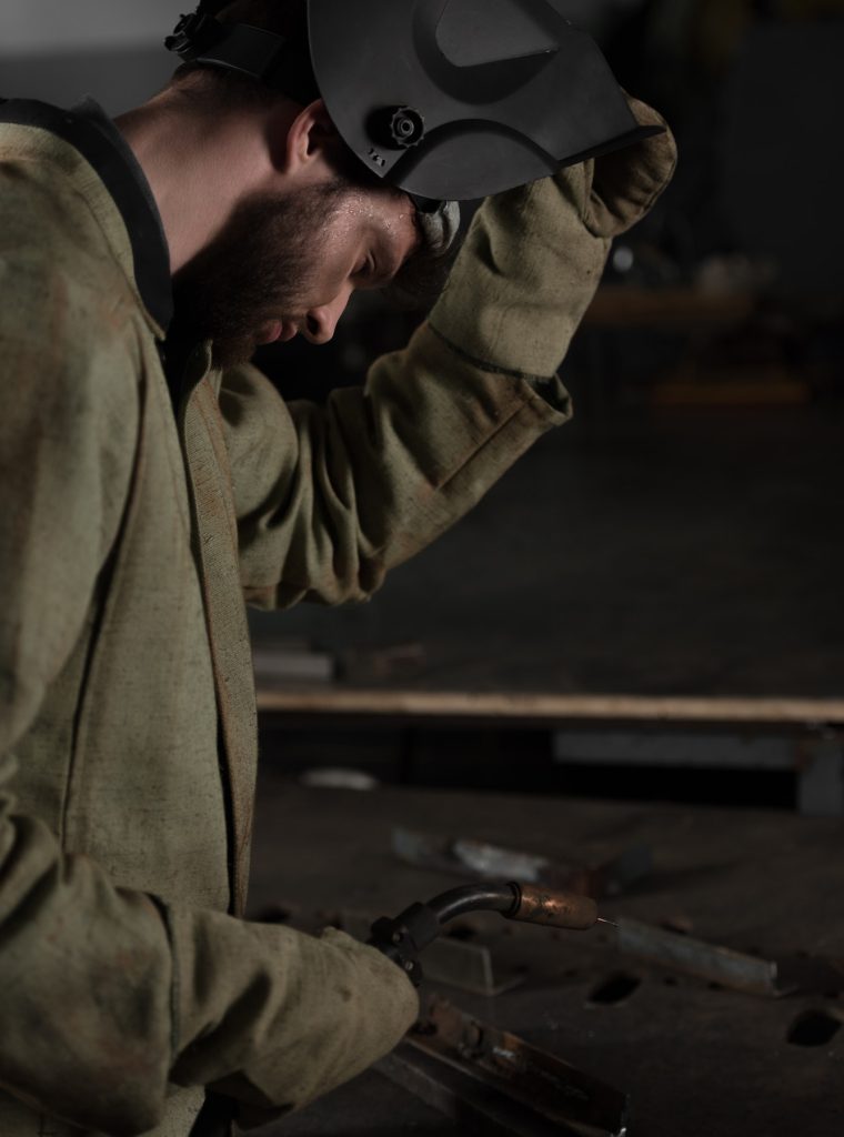 side-view-of-welder-lifting-up-protective-mask-to-look-at-his-work.jpg side-view-of-welder-lifting-up-protective-mask-to-look-at-his-work.jpg